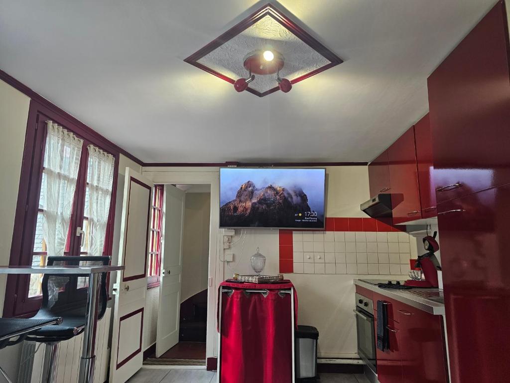 une cuisine avec un plafonnier et un réfrigérateur rouge dans l'établissement Petit Duplex, à Honfleur