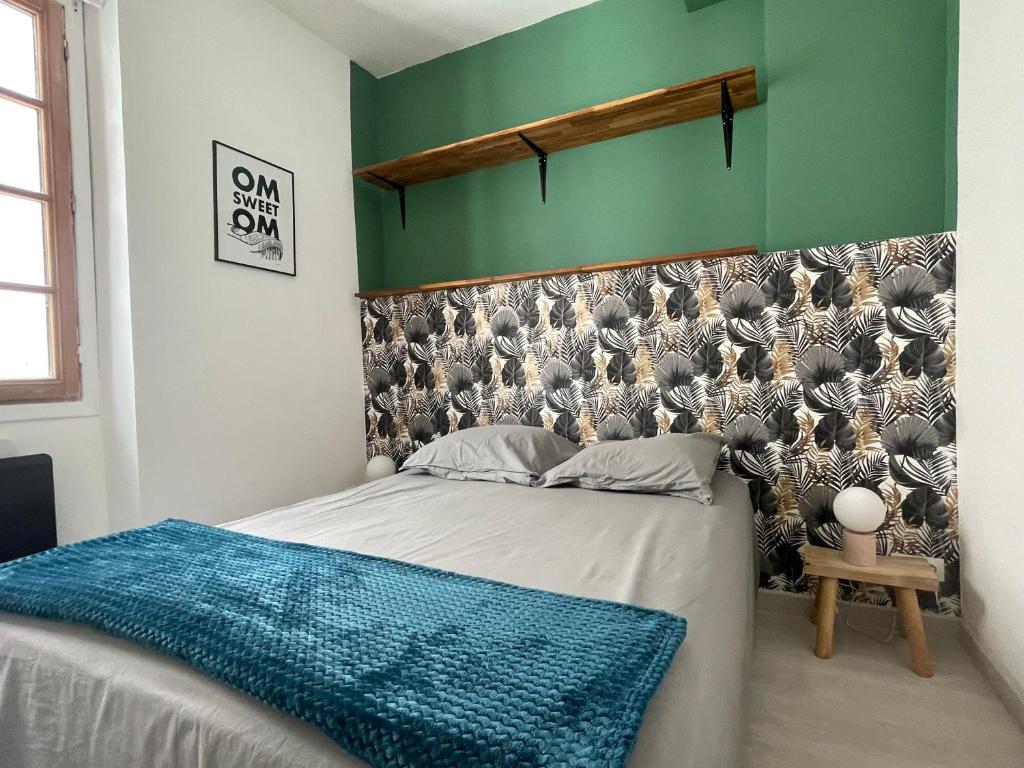- une chambre avec un lit doté d'une couverture bleue dans l'établissement Appartement entre la gare St Charles et Vieux port, à Marseille