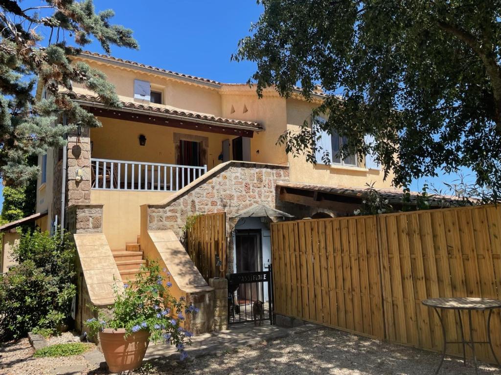 une maison avec une clôture en bois devant elle dans l'établissement Le Mas g'Ardéchois, à Saint-Paul-le-Jeune