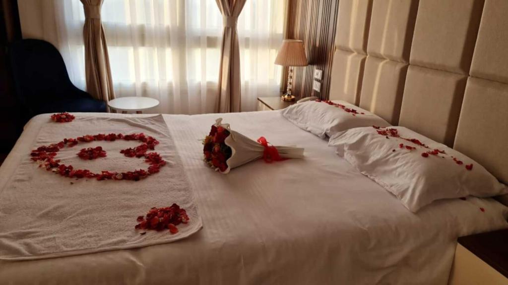 Una cama blanca con un corazón hecho de rosas. en Pyramids Sunshine View, en El Cairo
