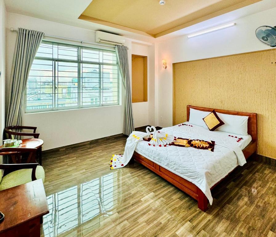 Un dormitorio con una cama y una ventana grande. en Đức Phúc Hotel, en Ho Chi Minh