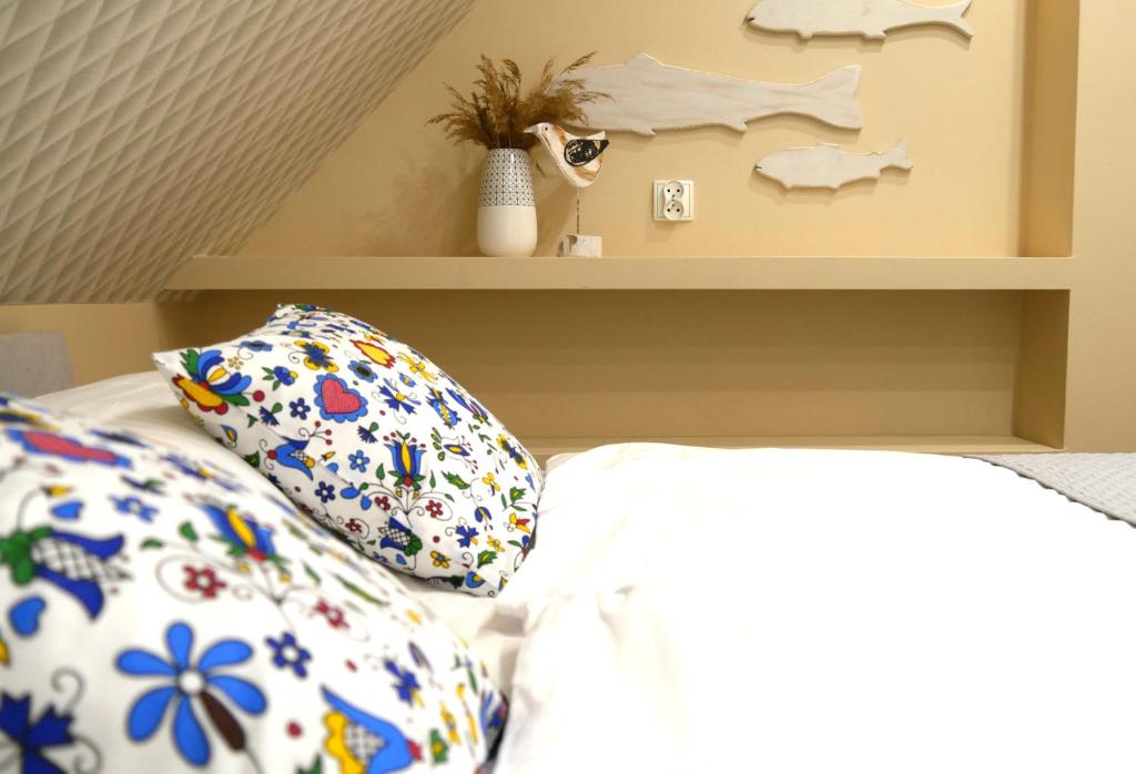 a bedroom with a bed with pillows and a shelf at Apartamenty Wakacyjne WICJAN in Chałupy