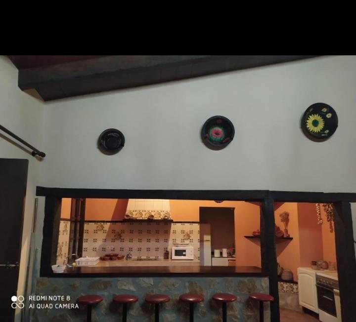 eine Küche mit einer Theke und einigen roten Hockern in der Unterkunft Villa Gracia in La Puebla de los Infantes
