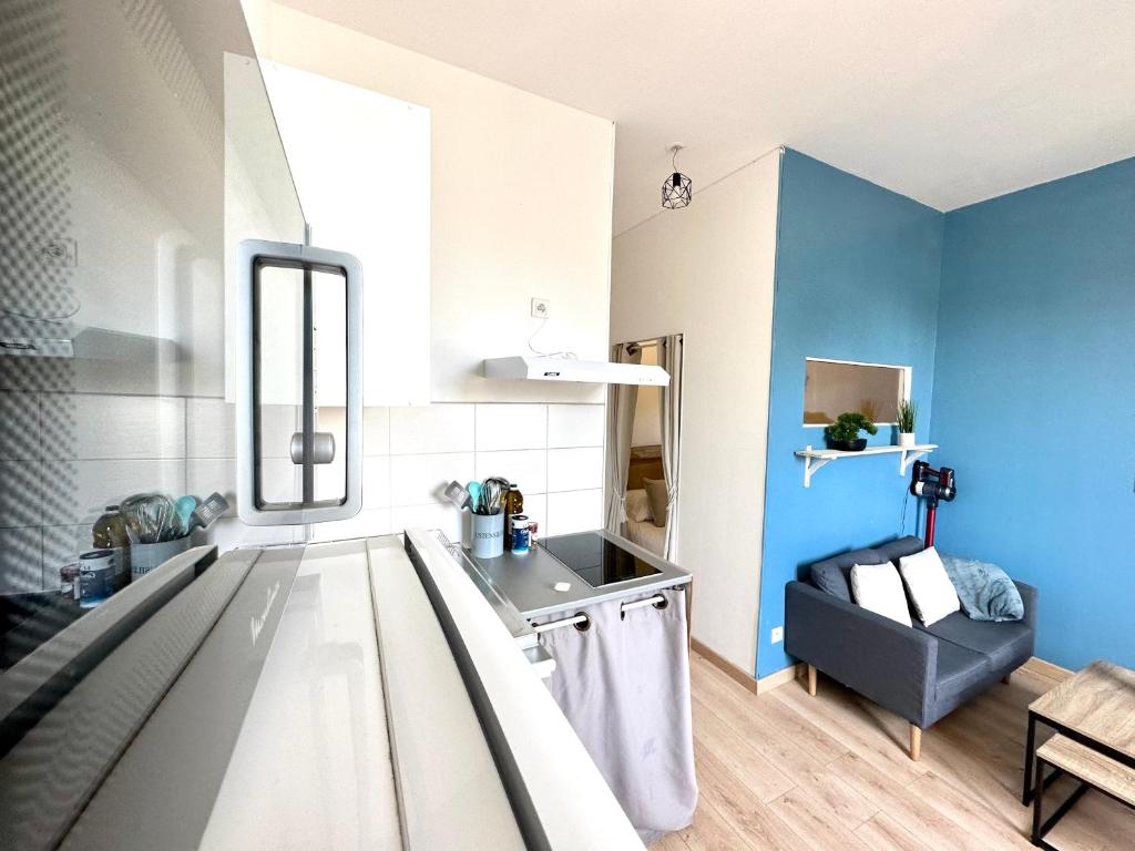 - une cuisine aux murs bleus et une table dans une chambre dans l'établissement Le Dumas, intime et cosy, à Limoges