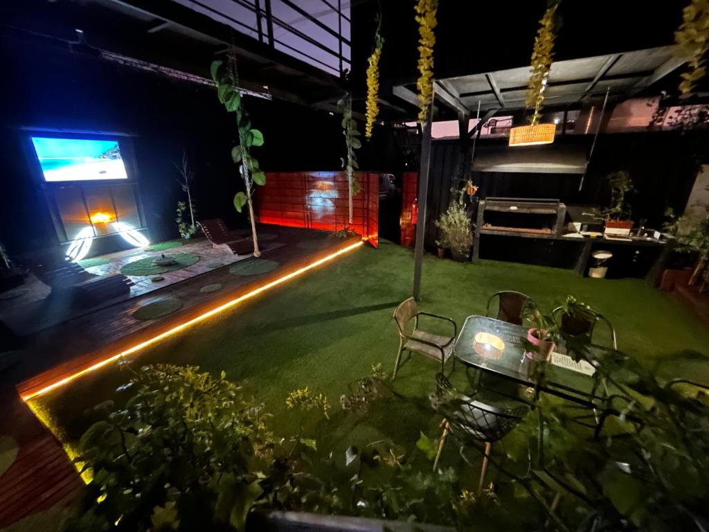 a backyard with a lawn with lights and a stage at Beehouse Casa Miel Villa Alemana in Villa Alemana