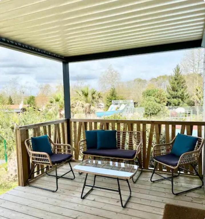 d'une terrasse avec trois chaises et une table. dans l'établissement Chalet à louer - 52m2 - Landes, à Saint-Geours-de-Maremne