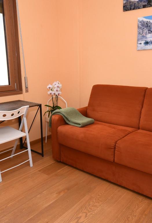a living room with a couch and a table at Appartamento Ca' Battaglia in Chiesa in Valmalenco