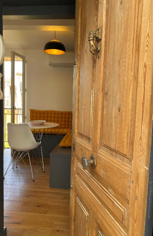 une porte ouverte menant à une chambre avec une table et une chaise dans l'établissement Studio centre historique Aix en Provence, à Aix-en-Provence