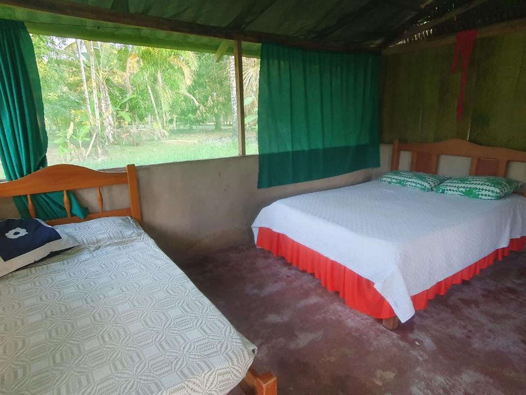 a bedroom with two beds in a tent at Centro de Medicina y Posada Indigenawa in Cruzeiro do Sul