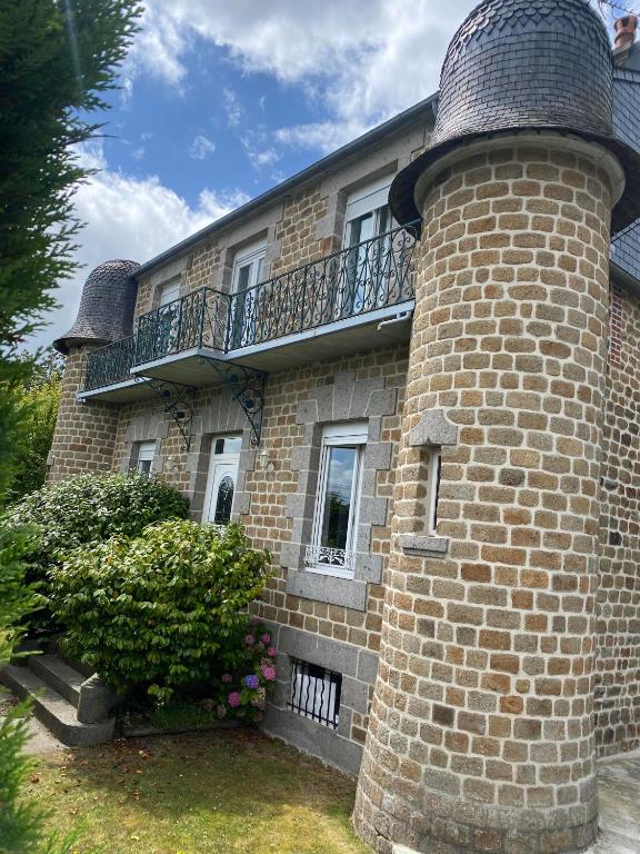 a brick building with a balcony on top of it at Villa Les Tourelles in Flers