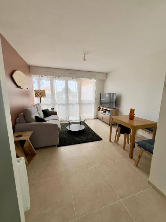 un salon avec un canapé et une table dans l'établissement Studio rénové proche de la plage, à Tarnos