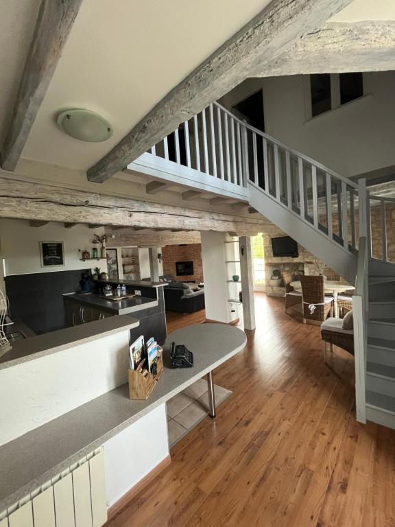 Il comprend une grande cuisine et un salon avec un escalier. dans l'établissement Gîte du soleil, à Saint-Maurin