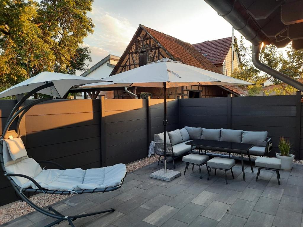 a patio with a table and chairs and an umbrella at Ganzes Tiny House "Thüringer Ruhe" mit großem Garten nahe Rennsteig in Laucha