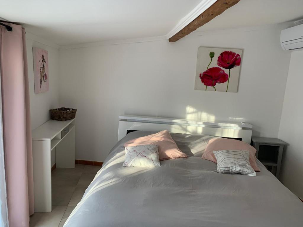 - une chambre avec un lit orné d'une rose rouge sur le mur dans l'établissement MAISON Ici, à Grimaud
