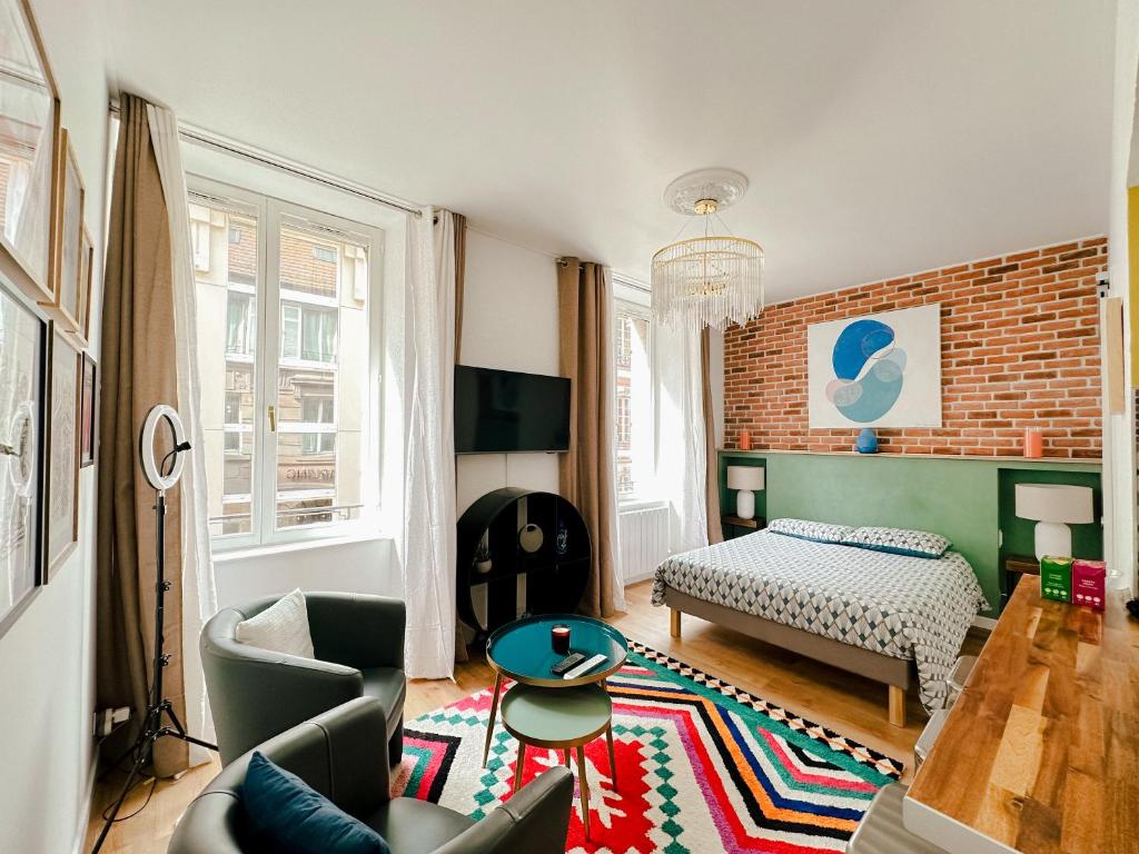 a living room with a bed and a couch at Suite Hyper Centre Strasbourg in Strasbourg