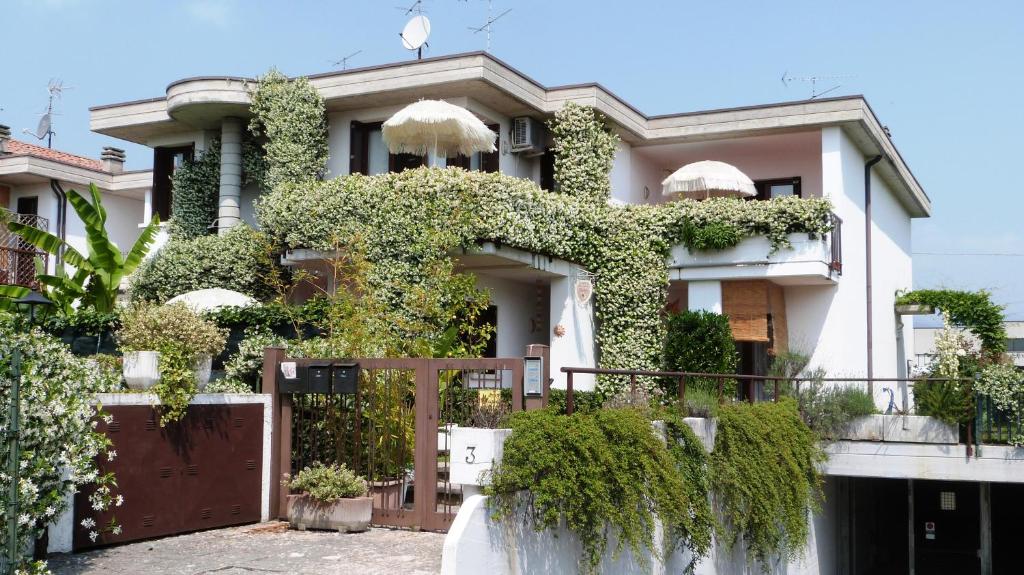 Una casa blanca con hiedra. en B&B Nautilus, en Puegnago sul Garda