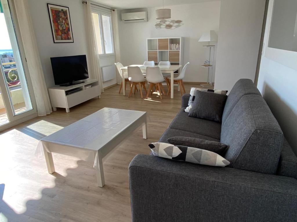 a living room with a couch and a table at VUE MER - Appartement T2 in Cannes