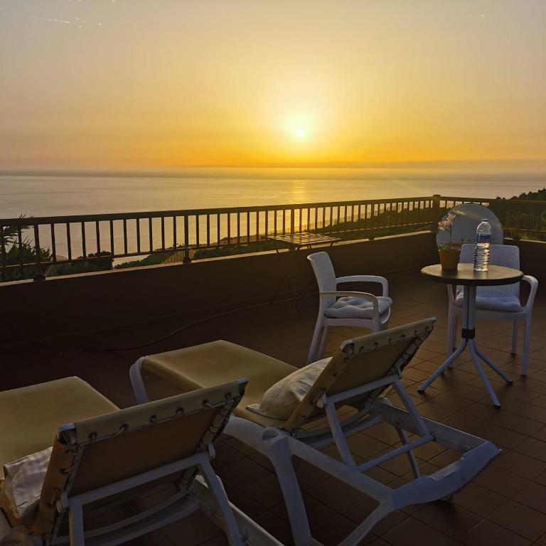 two chairs and a table on a balcony with the sunset at Los Padres C in Tijarafe
