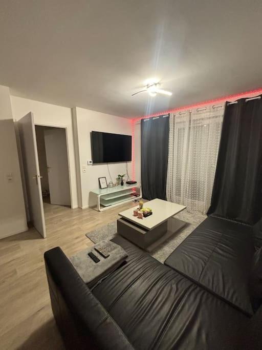 un salon avec un canapé et une table dans l'établissement Appart Cosy, à Montfermeil