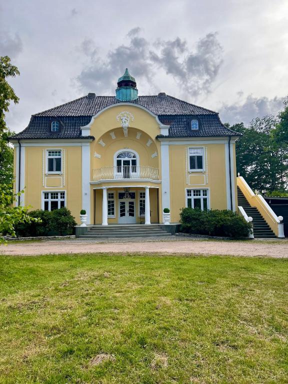 a large yellow house with a black roof at Wohnung im Schloss in Todendorf