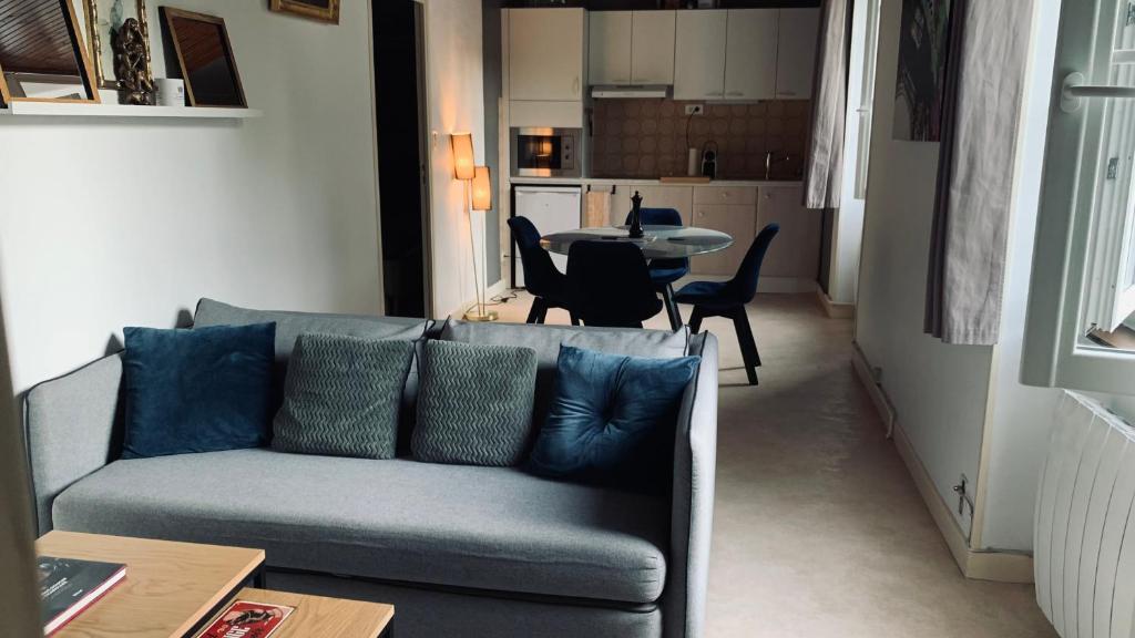 een woonkamer met een bank en een tafel bij La Garçonnière II in Charolles