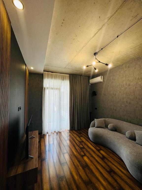 Una sala de estar con un sofá y un televisor. en Superior Apartment in Tbilisi, en Tiflis