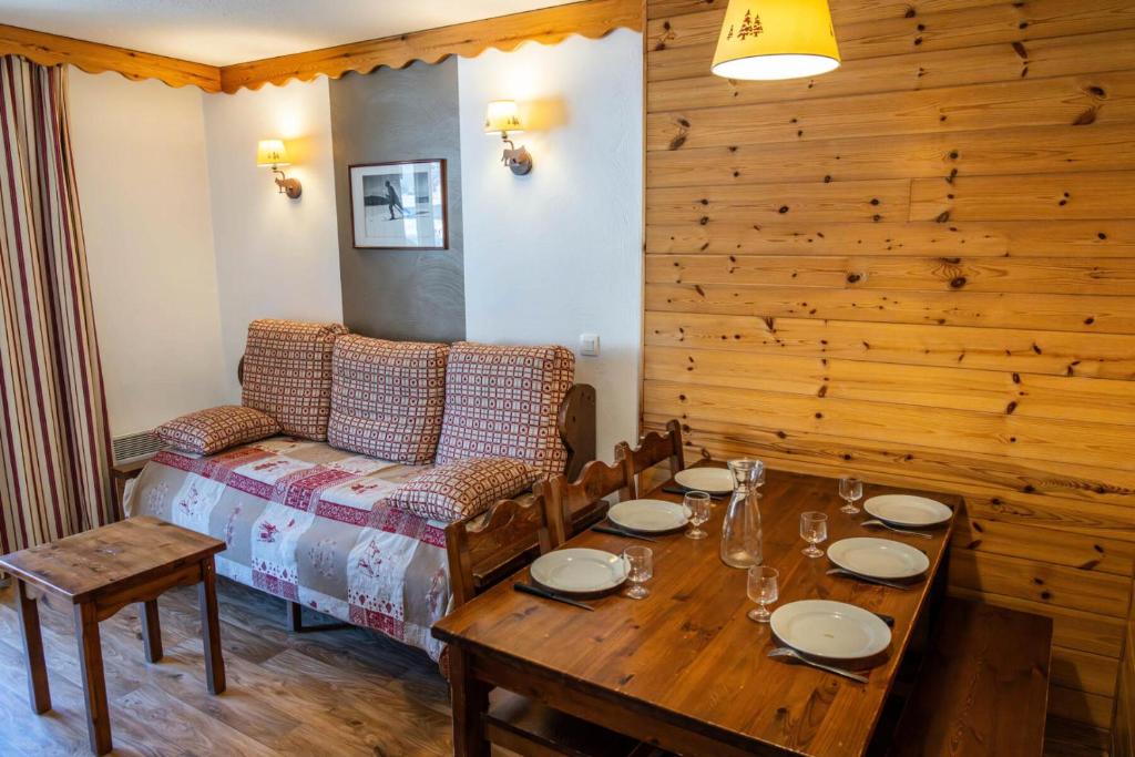 une salle à manger avec une table et un canapé dans l'établissement Résidence Les Hauts De Preclaux - Appartement 6 couchages au coeur des Orres 1800 MAE-9941, aux Orres