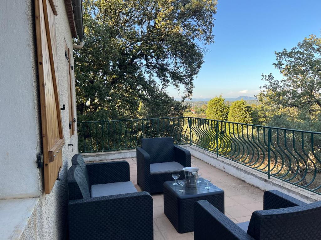 d'une terrasse avec des chaises et des tables sur un balcon. dans l'établissement Maison calme au cœur de la Sainte Baume, à Saint-Maximin-la-Sainte-Baume