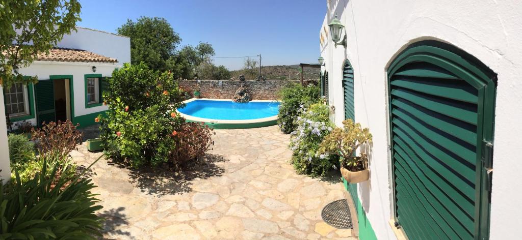 een achtertuin met een zwembad en een gebouw bij Casa Delfim - Casa Verde in Alte