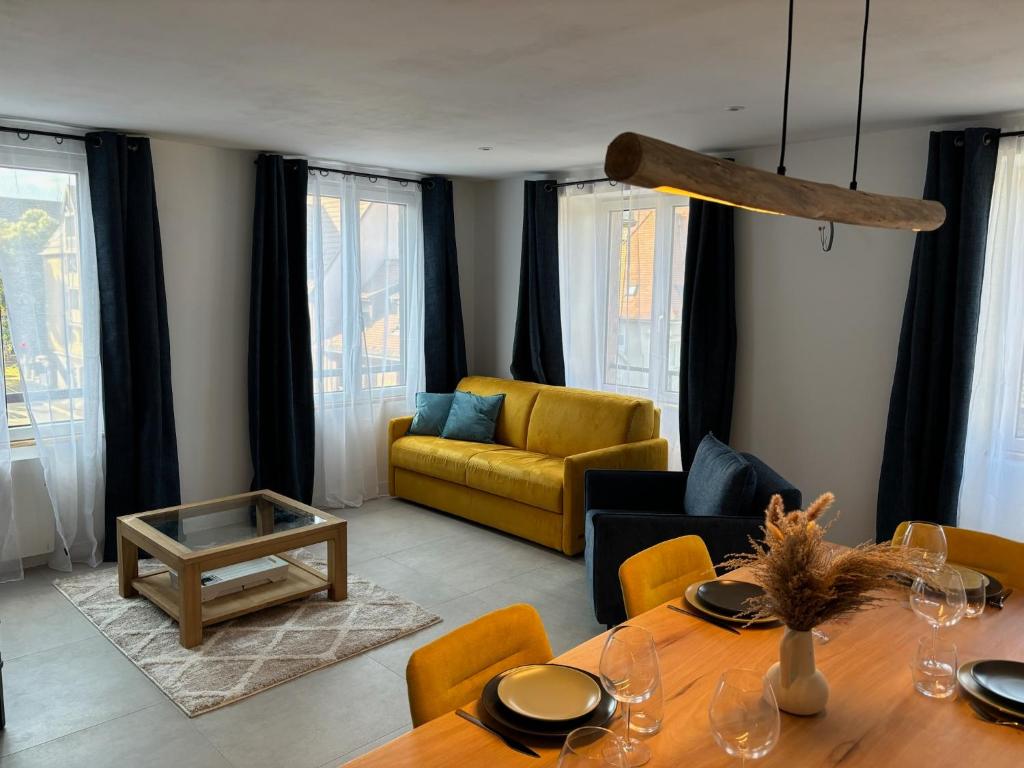 een woonkamer met een tafel en een bank bij Gîte Eden classer 3 étoiles in Colmar