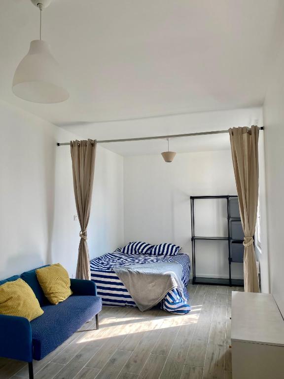 un salon avec un lit et un canapé dans l'établissement Chambre d'hôtes équipée et neuve, à Drancy