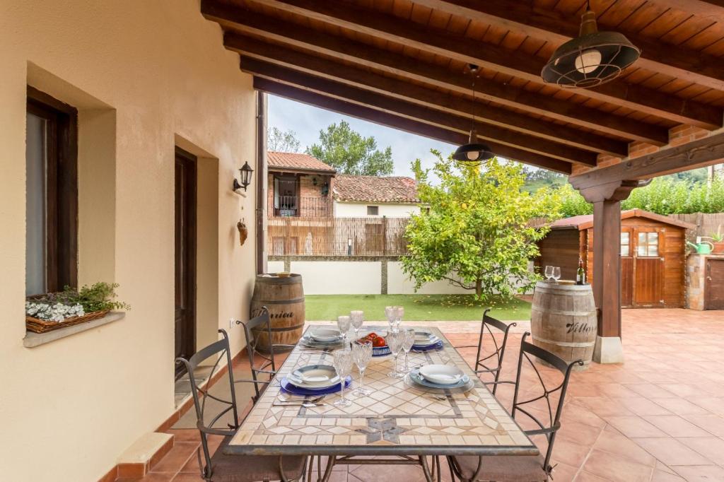 a patio with a table and chairs on a patio at El capricho de Laio in Pesués