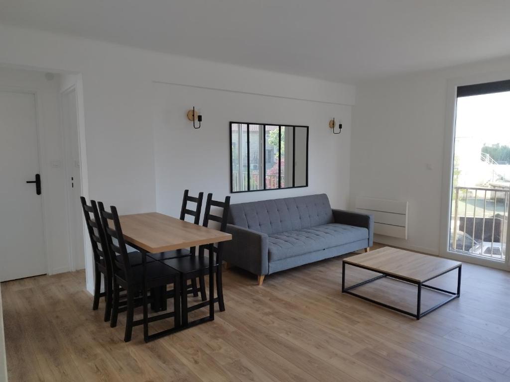 a living room with a couch and a table at Appartement traversant 2 chambres in Ajaccio