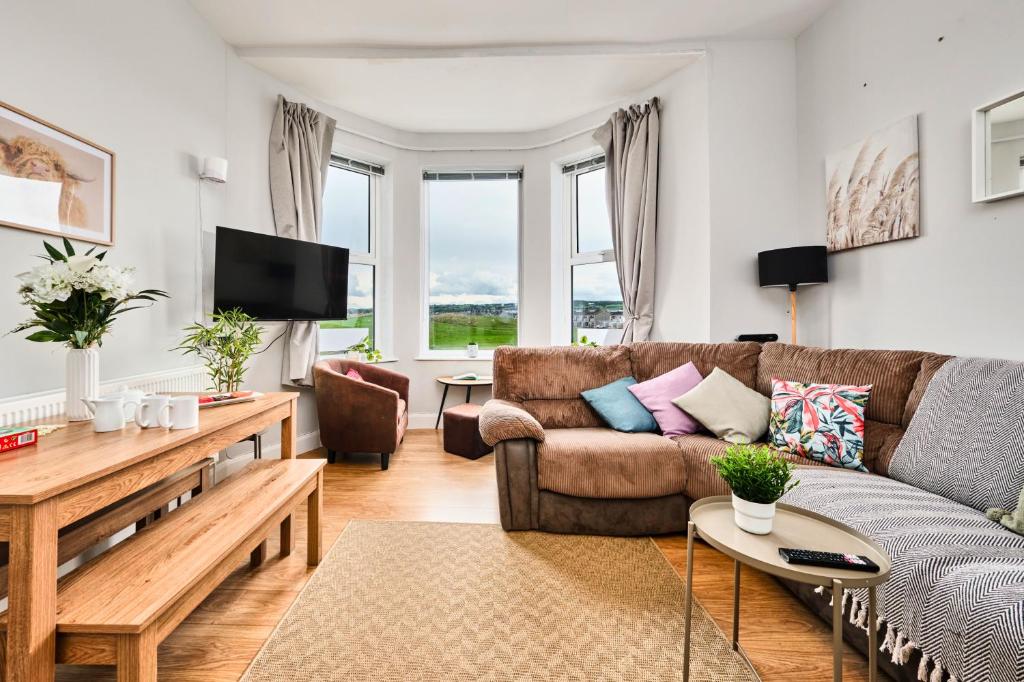 a living room with a couch and a table at Dunluce Green 2 - Portrush by the Sea in Portrush