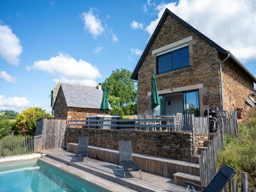 a stone cottage with a swimming pool and a house at Gite Les Corbieres in Cassaniouze