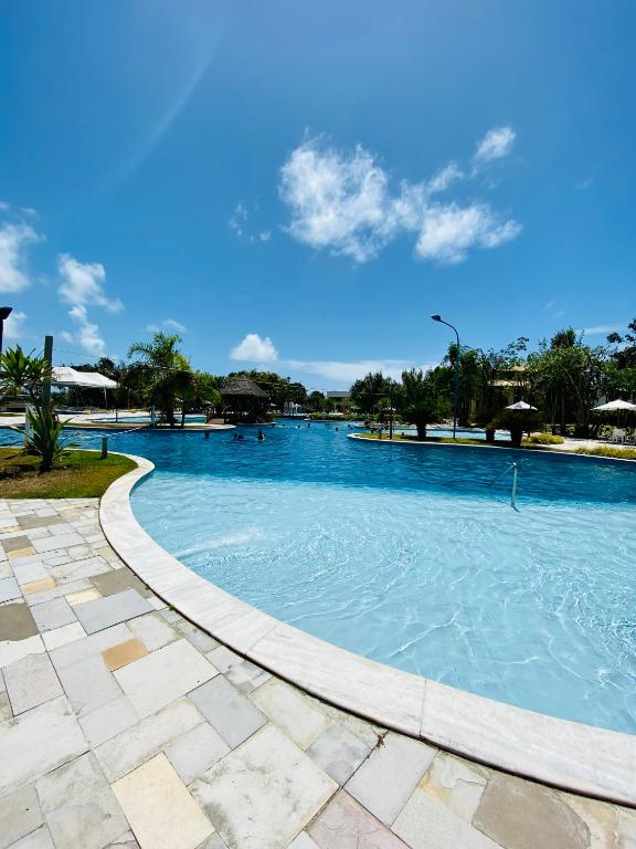 a large swimming pool with blue water at Iloa Condo Supreme Hospedagens in Barra de São Miguel