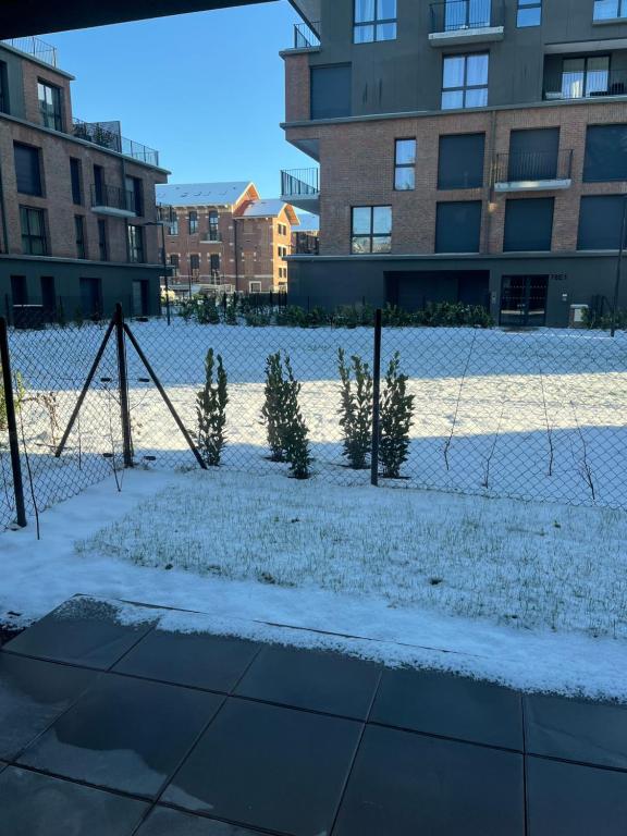 ein schneebedeckter Spielplatz vor einem Gebäude in der Unterkunft Appartement neuf cosy in Saint-André