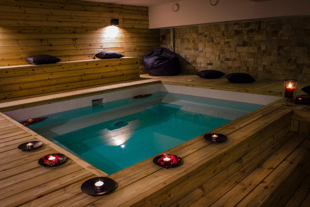 una vasca idromassaggio in una camera con pavimenti in legno di Trigrad Hotel a Trigrad