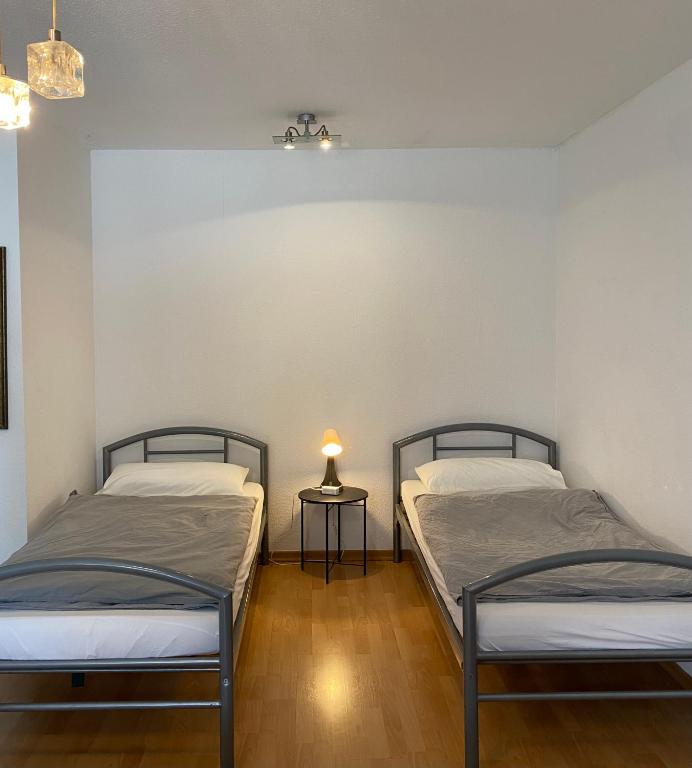 two beds in a room with a lamp on a table at Düsseldorf 1995 in Düsseldorf