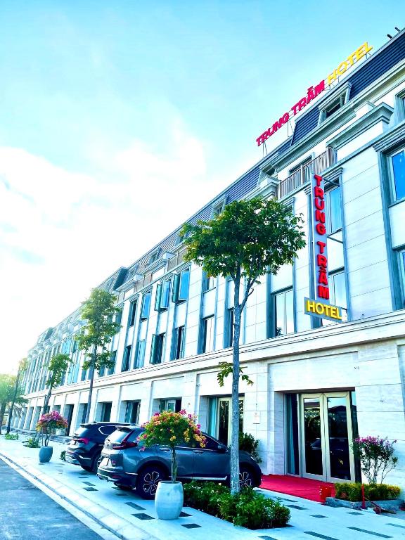 a hotel building with cars parked in front of it at Khách sạn Trung Trầm in Dong Hoi