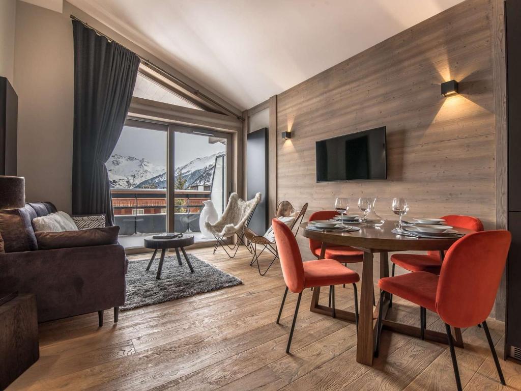 un soggiorno con tavolo, sedie e TV di Location 5 pers. à Courchevel - 2 pas des pistes, centre station, spa, parking inclus, WiFi, parking - FR-1-631-199 a Courchevel