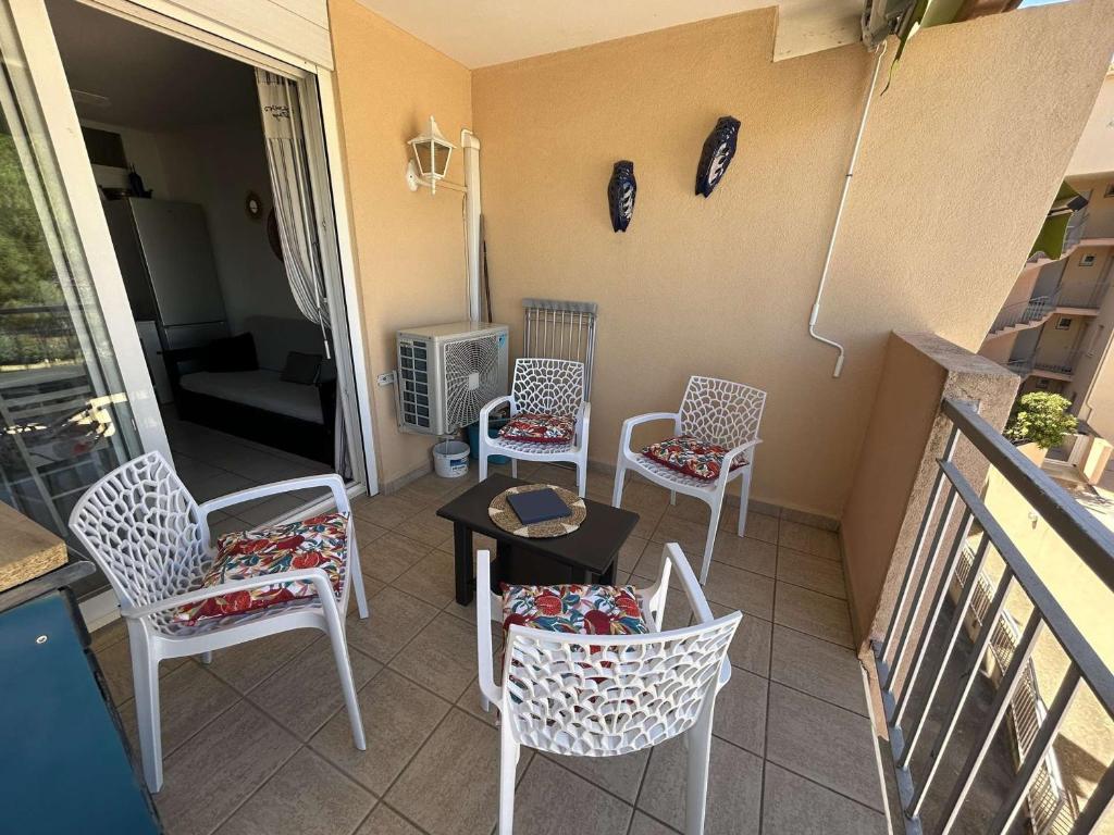 d'un balcon avec des chaises, une table et un radiateur. dans l'établissement Appt 2 pièces cabine climatisé avec piscine et parking à Port Camargue - FR-1-250-292, au Grau-du-Roi