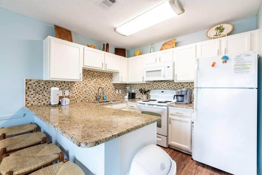 eine Küche mit weißen Schränken und einem weißen Kühlschrank in der Unterkunft Gulf View, Easy Beach Access, Heated Pool, Hot Tub in Destin
