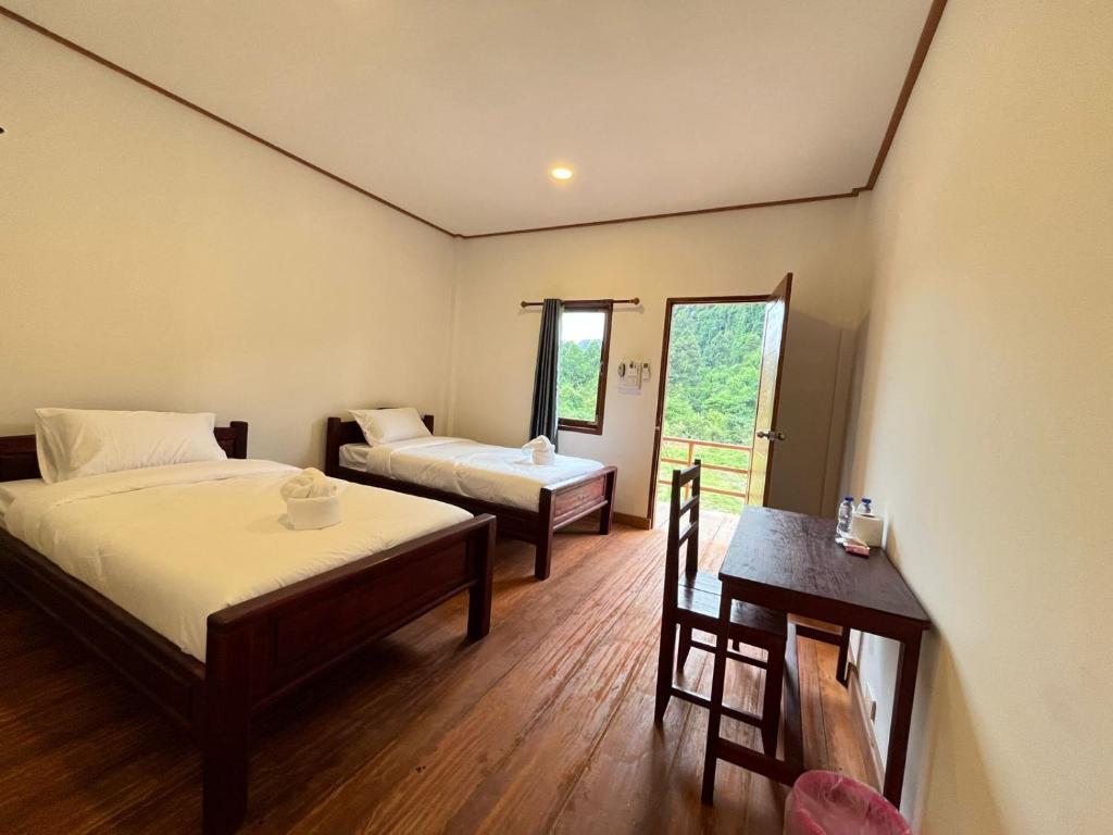 een hotelkamer met twee bedden en een tafel en een tafel sidx sidx bij Konglor Cave Resort-Riverside Restaurant in Ban O