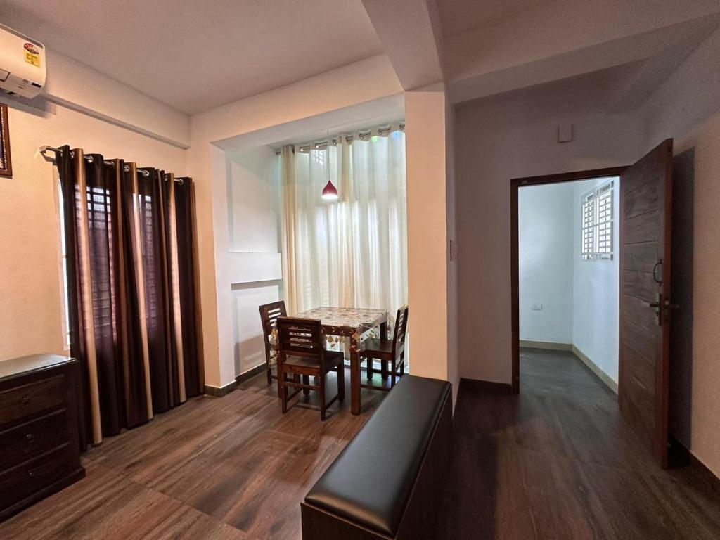 德里久尔DB Apartment Arimpur的一间有桌椅的房间和一间餐厅