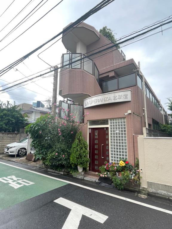 Hotel 新宿安靜の家-A quiet home in Shinjuku - a 26 square meter double bed room that feels like home206, a building with a red door on the side of a street at 新宿安靜の家-A quiet home in Shinjuku - a 26 square meter double bed room that feels like home206 in Tokyo