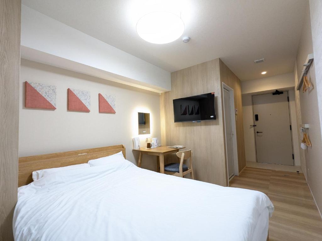 Postel nebo postele na pokoji v ubytování Nikko Beans Hotel
