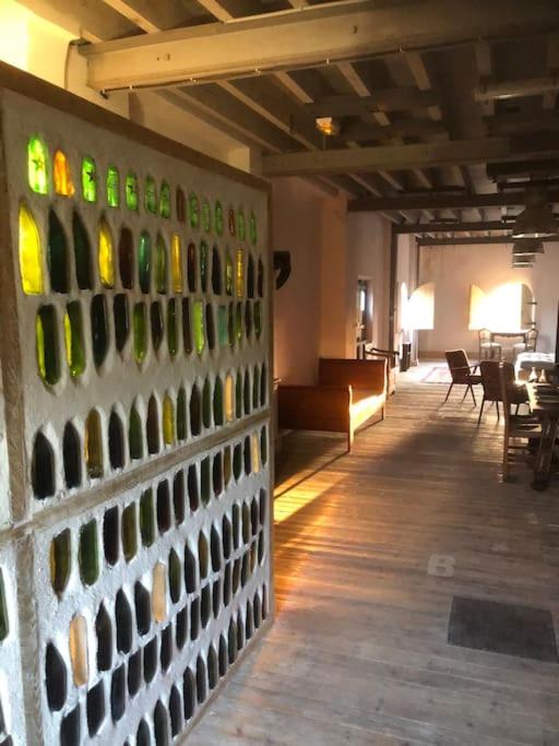 - un mur avec des bouteilles de vin dans la chambre dans l'établissement Loft dans Minoterie Les Grands Moulins de Ruffin, à Bréchamps