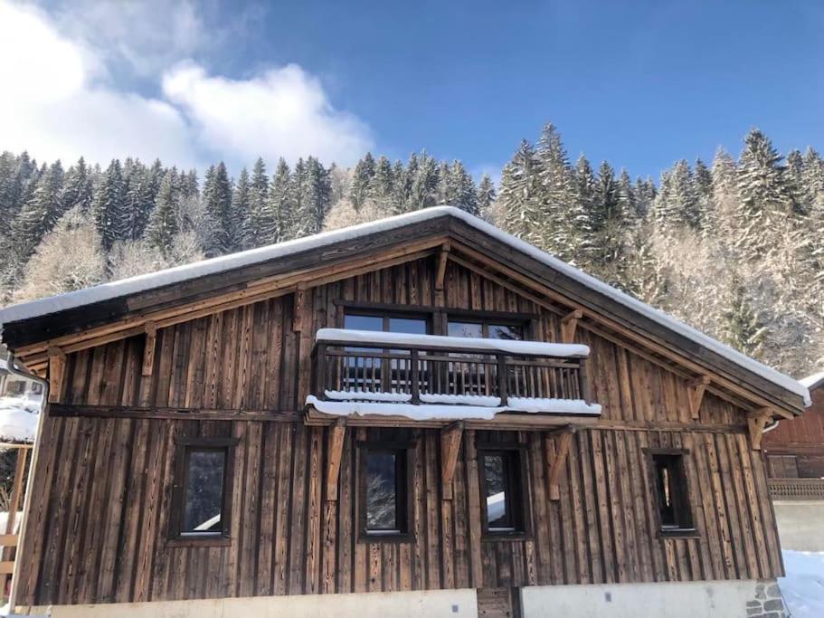 モルジヌにあるLa Grangette Apartment B Great Locationのバルコニーがあり雪が積もった木造の建物