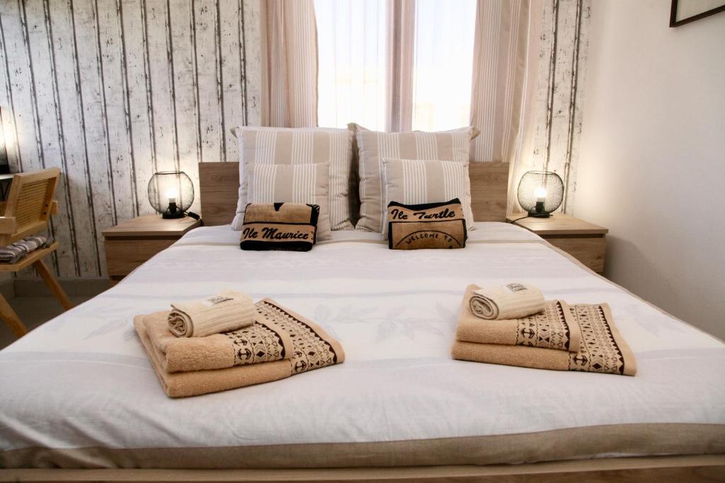 a bedroom with a white bed with towels on it at Luxueux Appartement 3 chambres in Flic-en-Flac